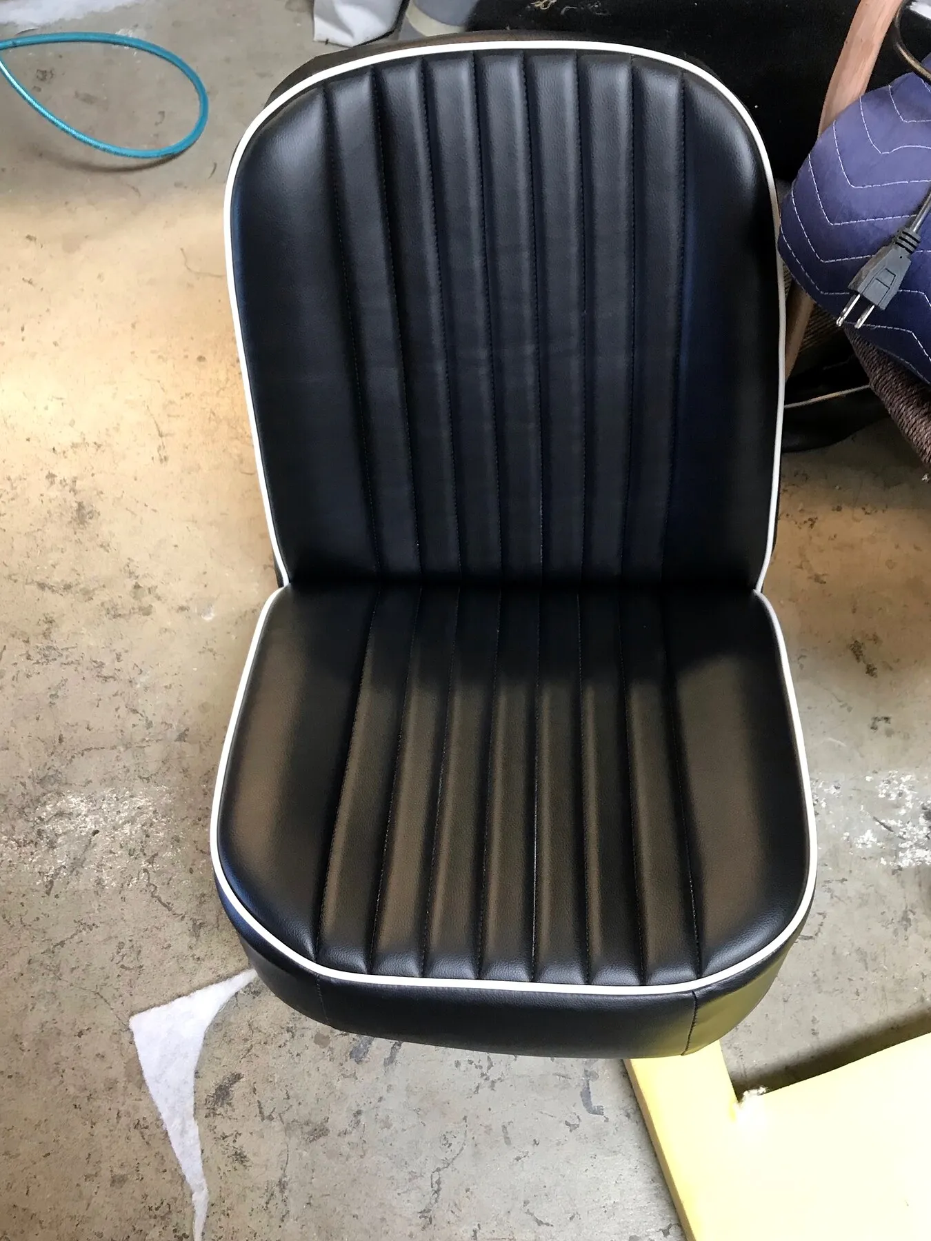 Black vinyl boat seat with stitched channels.