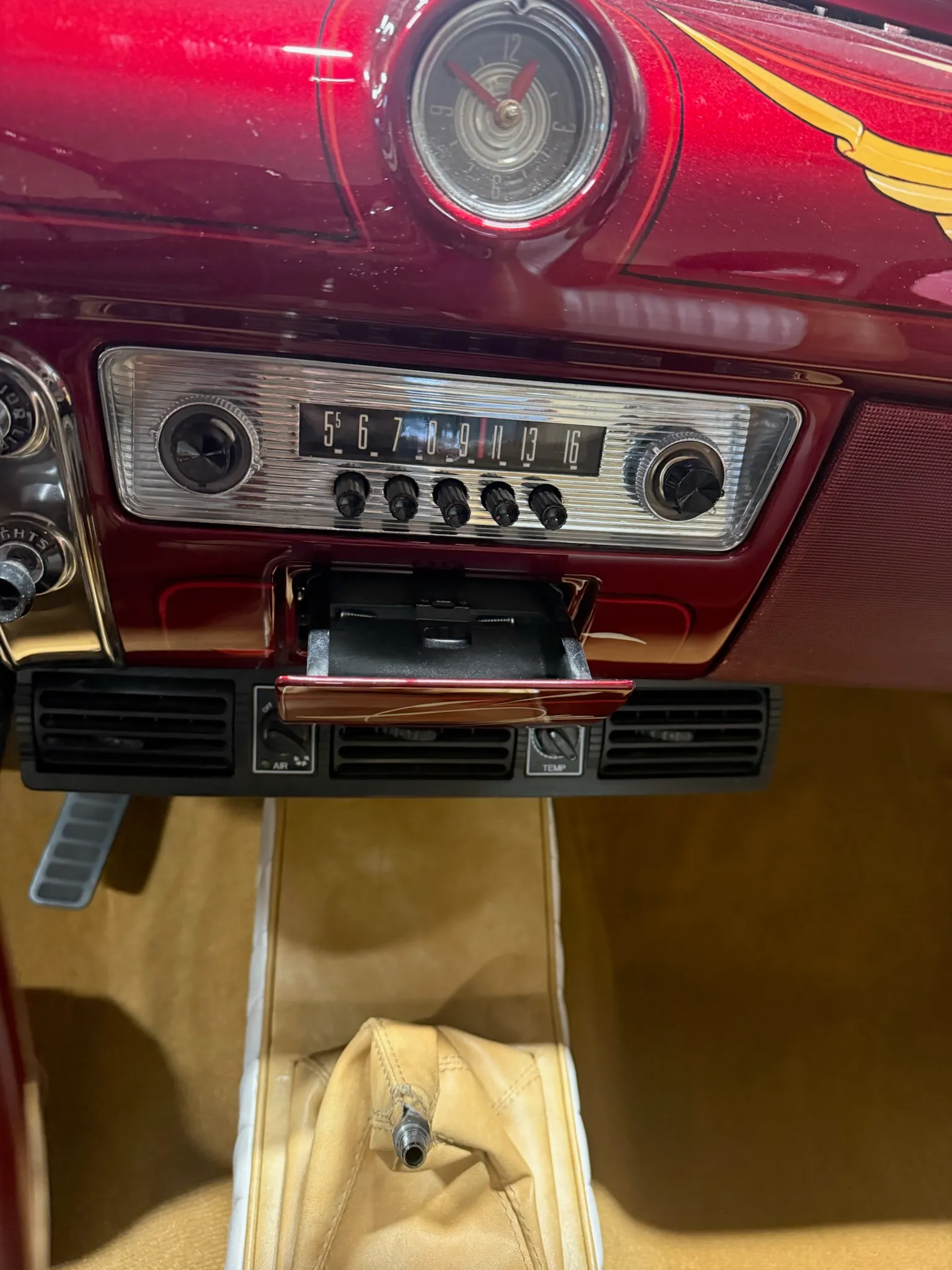 Buick Eight dashboard with chrome radio and tan carpeted console.