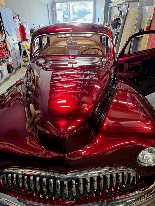 Front view of restored Buick Eight with deep red paint and chrome grille.
