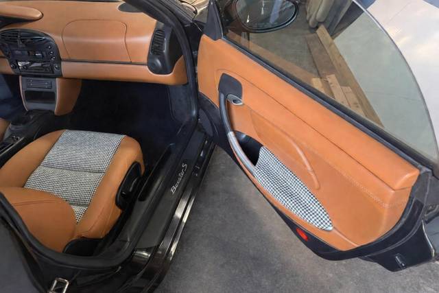 Porsche Boxster S door panel with matching houndstooth insert and saddle leather trim.