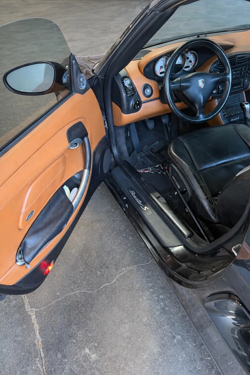 Driver door open showing Porsche Boxster S seat and door panel materials.