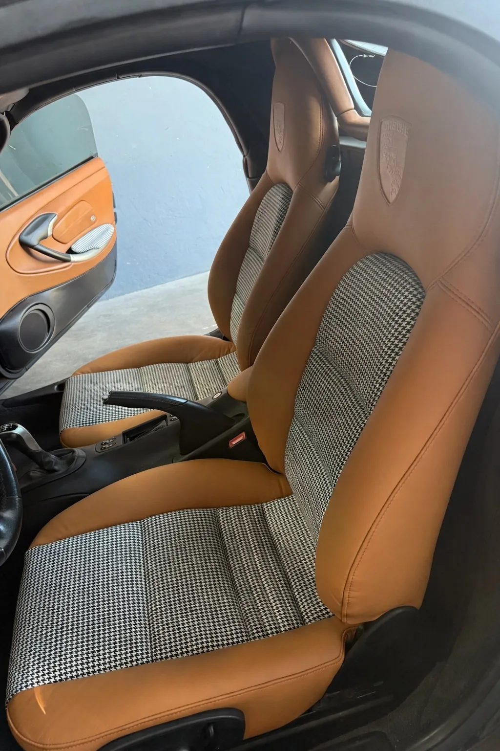 Porsche Boxster S front seats installed with saddle leather bolsters and houndstooth inserts.