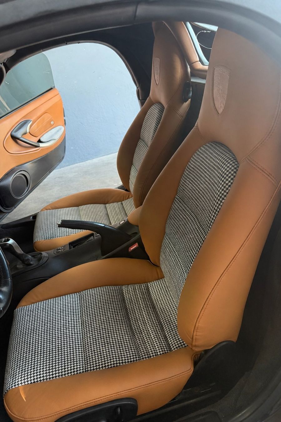 Porsche Boxster S front seats installed with saddle leather bolsters and houndstooth inserts.